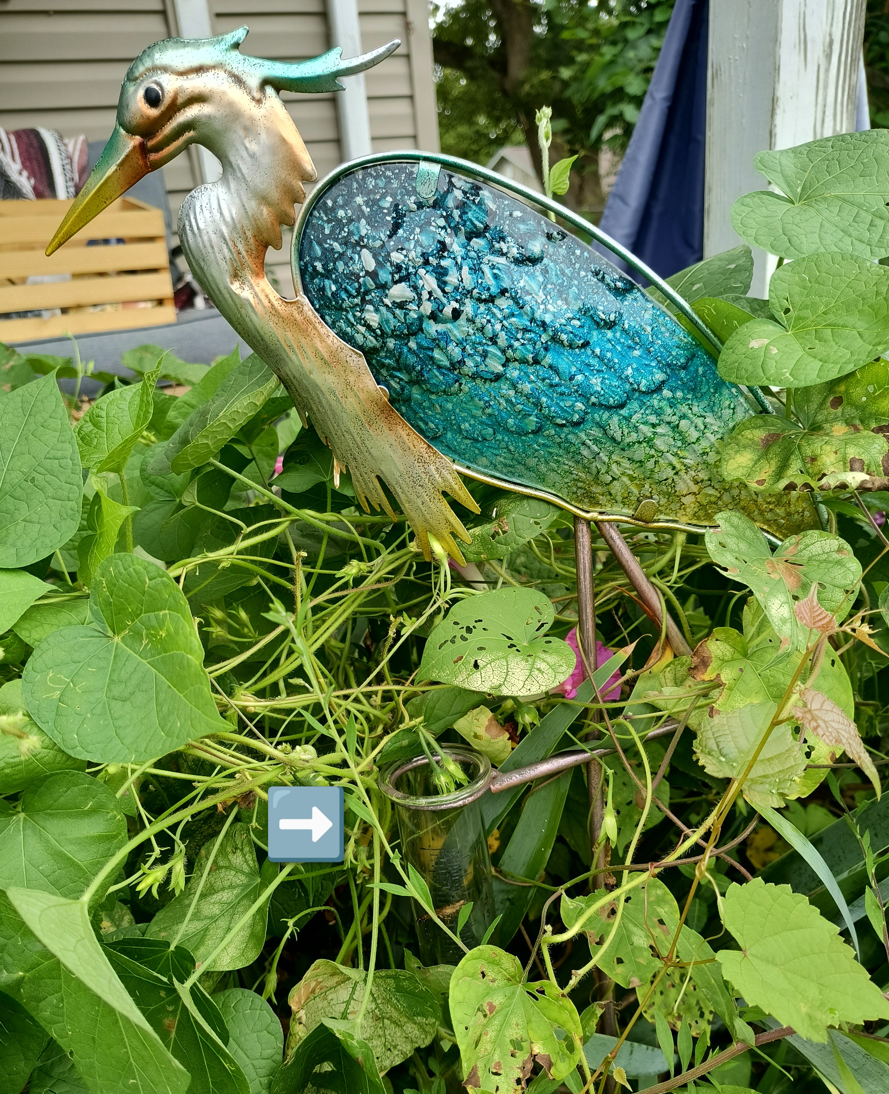 A heron statue that doubles as a rain gauge, with a glass tube marked with measurement lines